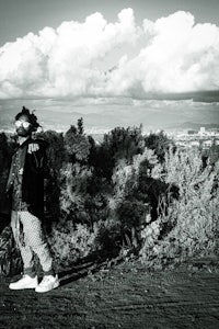 a black and white photo of a person standing on a dirt road