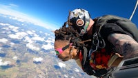 a man with dreadlocks and a helmet on a parachute